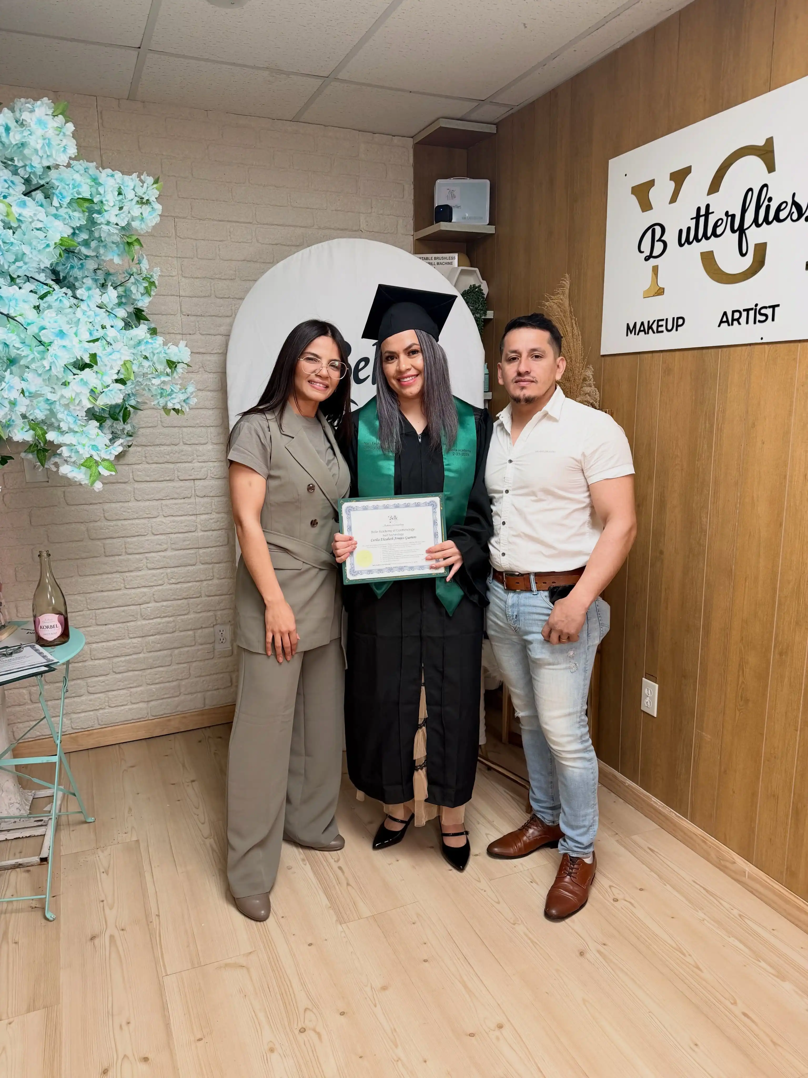 Graduate with family members celebrating Belle Academy certificate