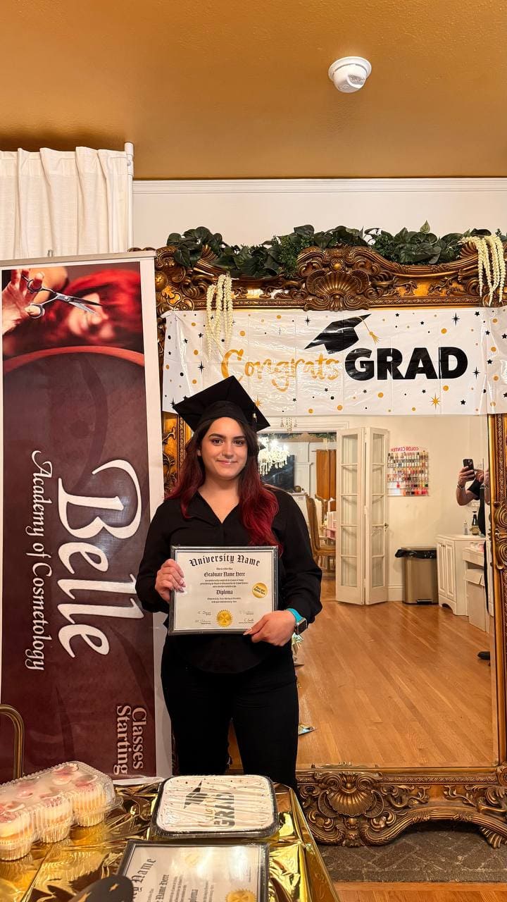 Belle Academy graduate in cap and gown at photo booth